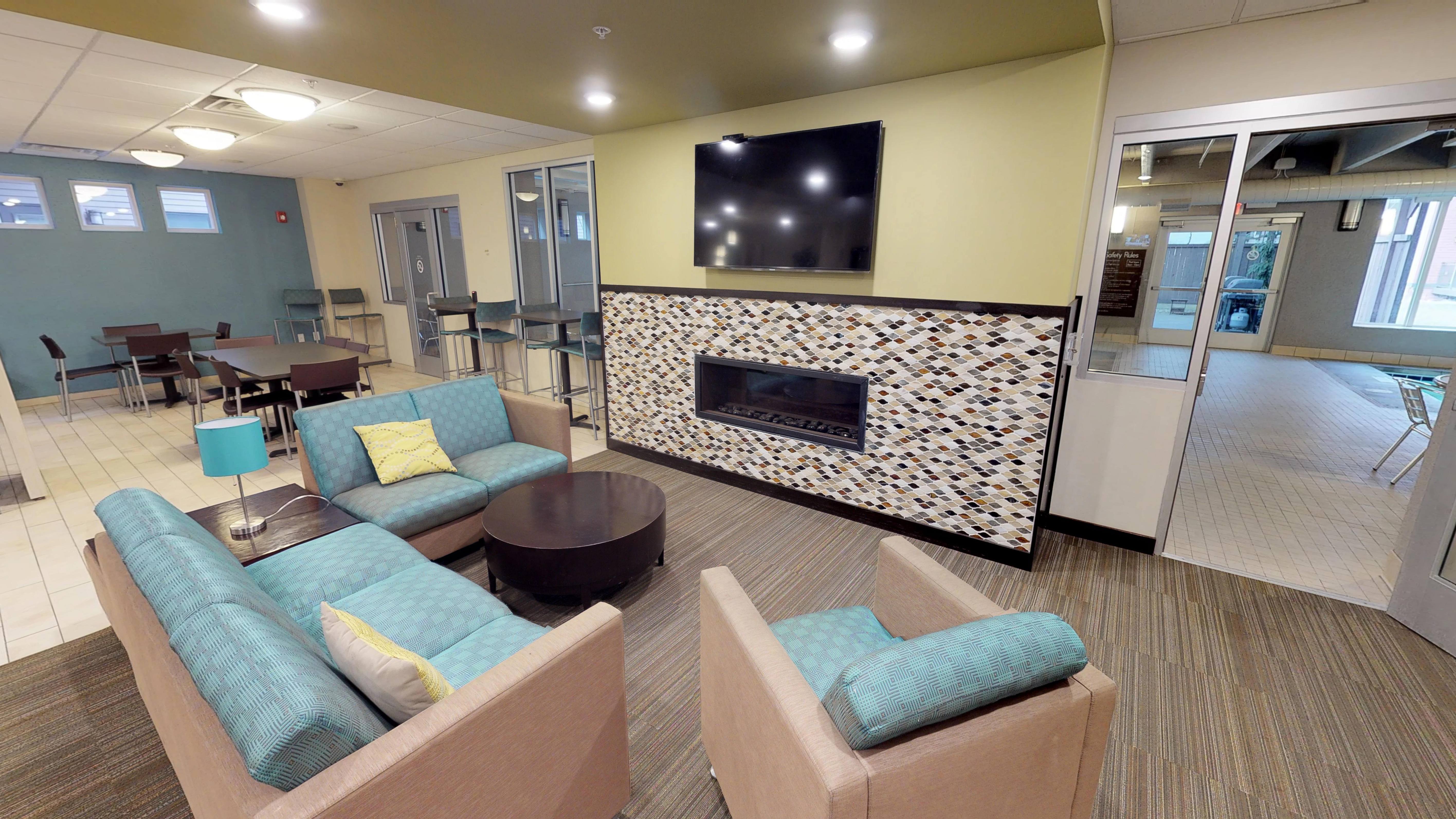 A living room with a fireplace and a television.
